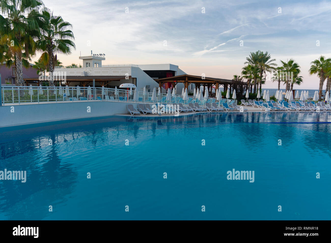 Alanya, Türkei - Oktober 05, 2018. Schönen Pool in Kirman Sidera Luxushotel mit klaren, blauen Wasser auf dem Hintergrund von Meer, blauer Himmel und grünen Palmen tr Stockfoto