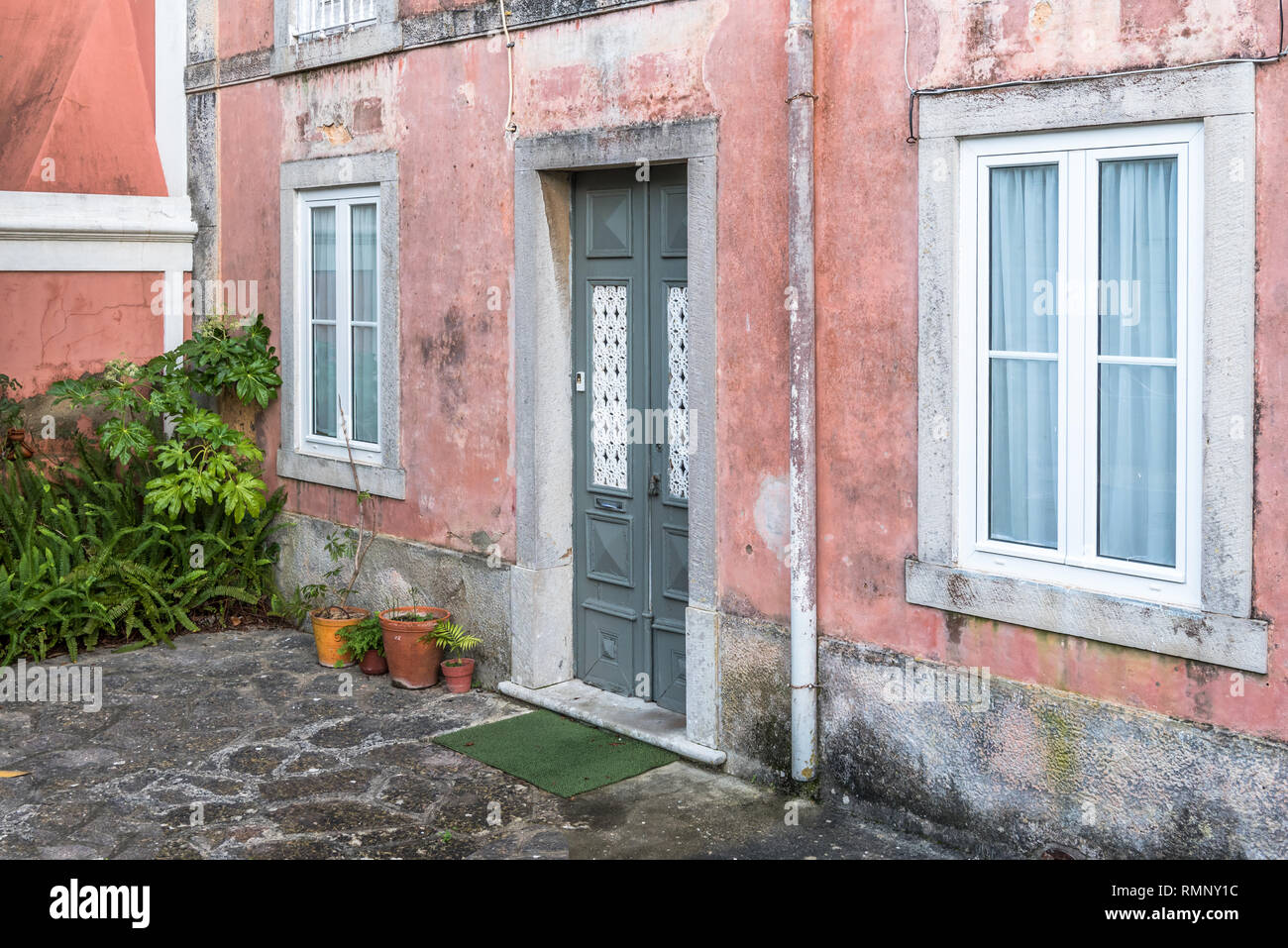 Tor Eingang der traditionellen street house mit gepflasterten Vorplatz Garten in der Altstadt von Cascais Portugal Stockfoto