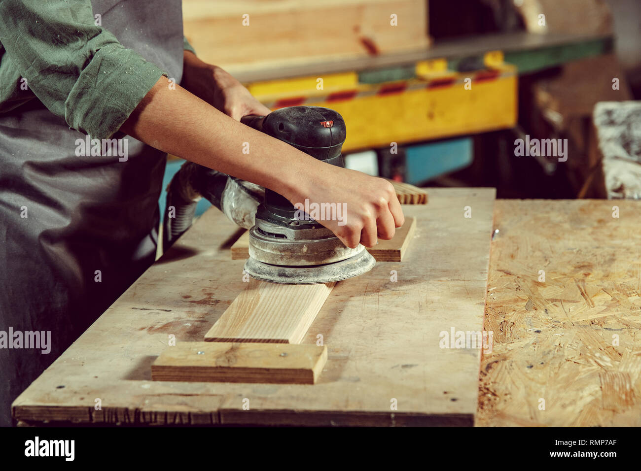 Hände von handwerkerin Schleifen Hölzer mit einer speziellen Maschine. Konzept der Tischler Shop und Holzbearbeitung. Gleichstellung von Frauen und Männern. Männliche Beruf Stockfoto