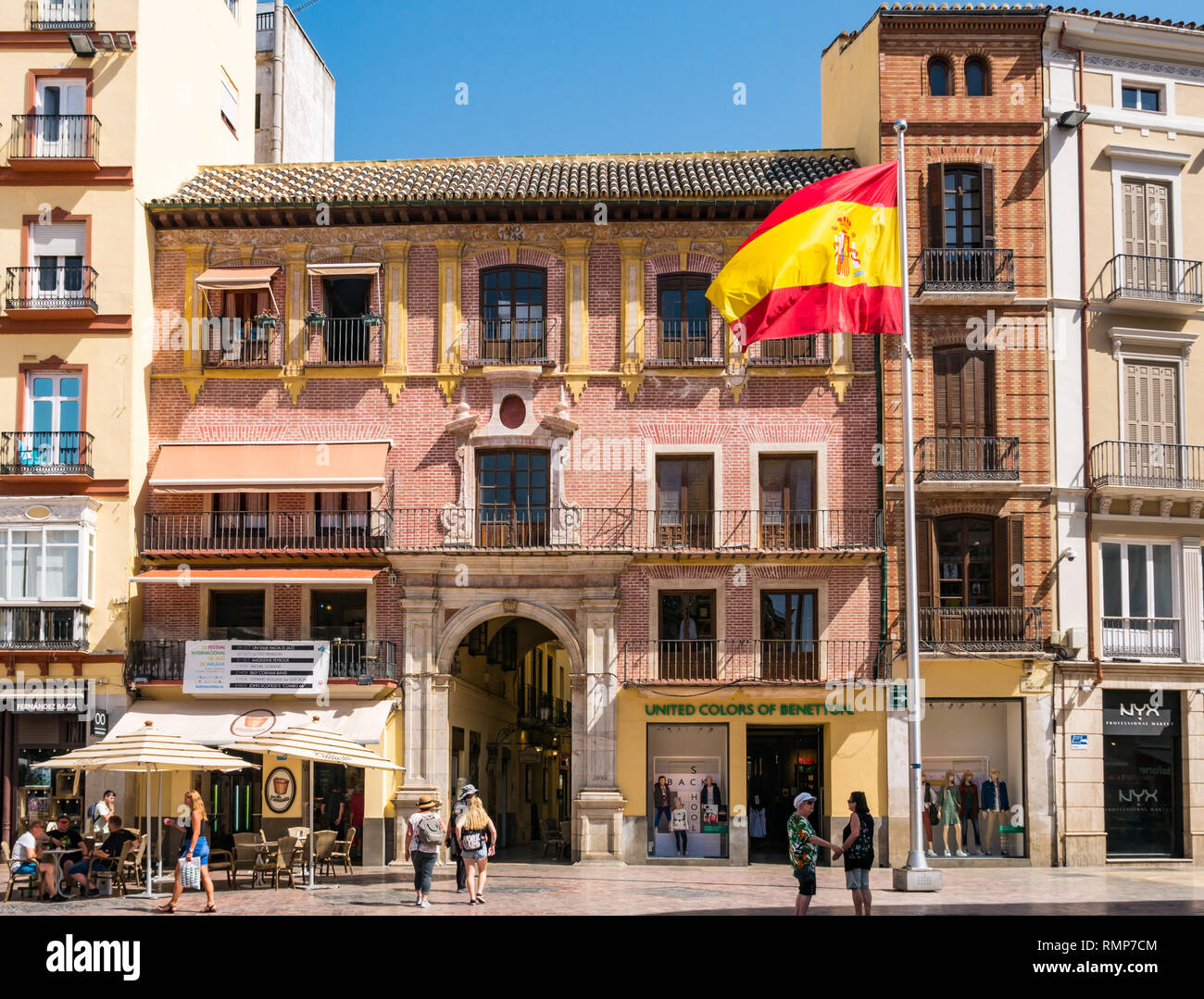 Altes Backsteingebäude, das jetzt die vereinigten Farben der Benetton store und spanische Flagge, die Plaza de la Constitucion oder Platz der Verfassung, Malaga, Andalusien, Spanien Stockfoto