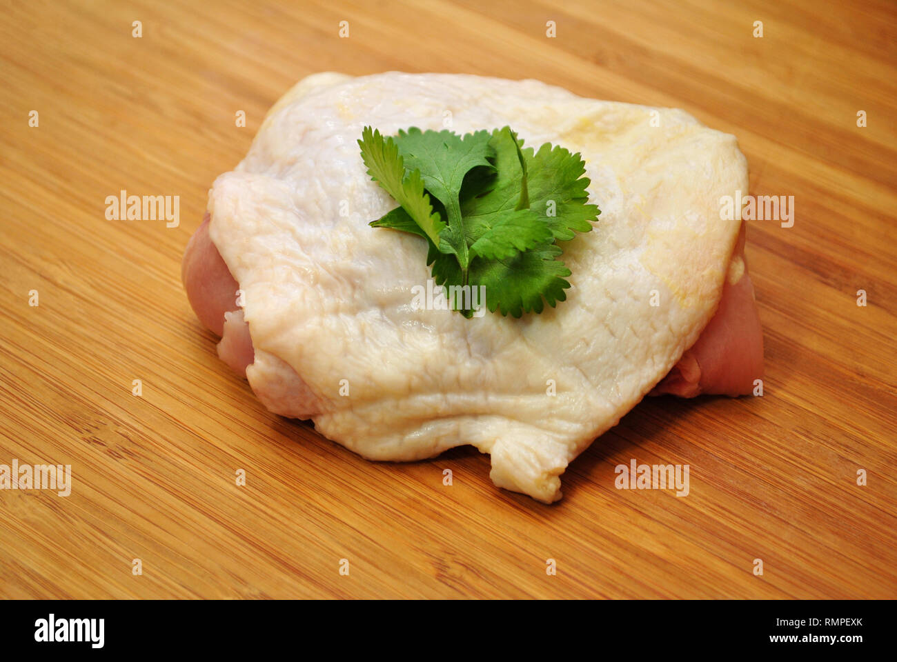 Rohes Huhn Oberschenkel garniert mit Petersilie Stockfoto