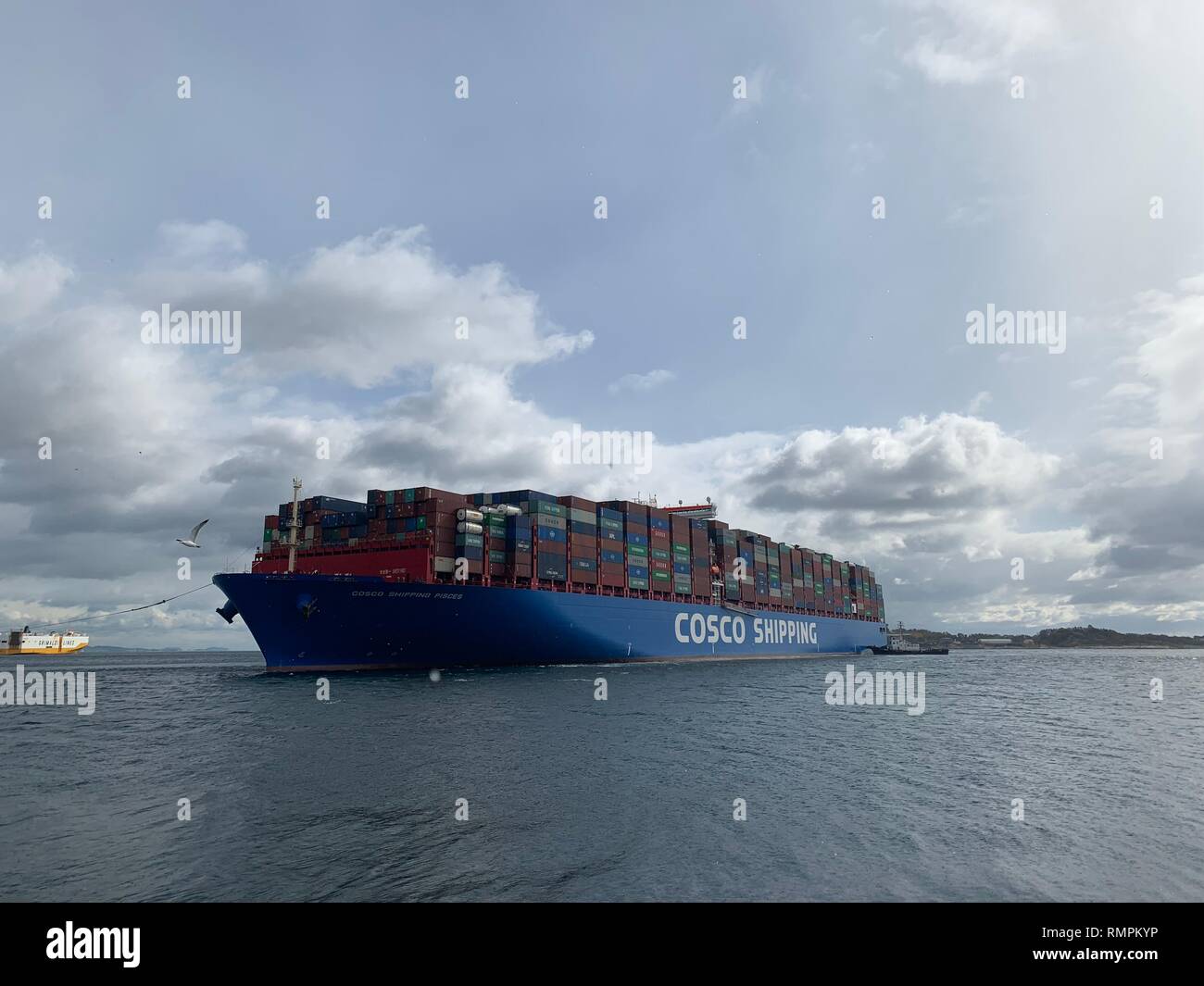 Piräus, Griechenland. 15 Feb, 2019. COSCO Versand Fische, einem der größten Containerschiffe der Welt mit einer Kapazität von 20.000 TEU, das ist gesehen auf dem Dock von Piräus, Griechenland, Feb.15, 2019 geschleppt. Das Schiff segelte fast ein Monat aus China, und es wird Dock am Hafen Piräus für 24 Stunden vor Beginn ihrer Reise zum Hafen von Antwerpen in Belgien. Credit: Yu Shuaishuai/Xinhua/Alamy leben Nachrichten Stockfoto