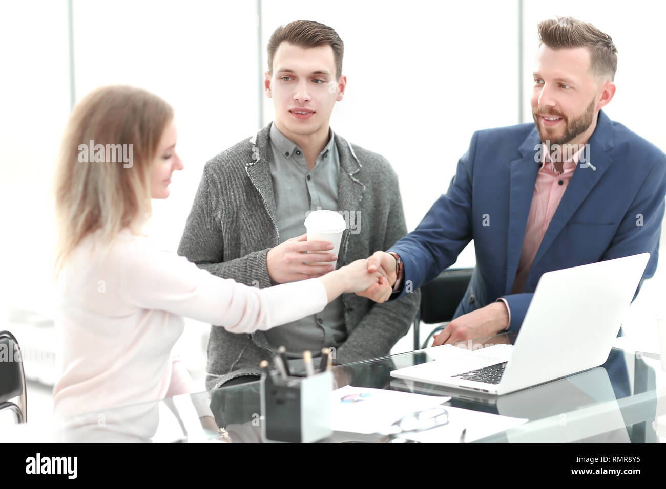 Kaufmann und Kauffrau schütteln sich die Hände an einem angenehmen Business Meeting. Stockfoto