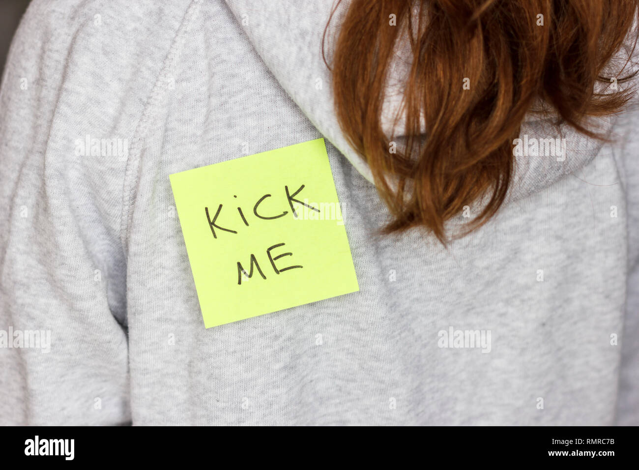 Aufkleber 'Kick me' auf jugendliche Mädchen zurück. 1. april Scherz  Stockfotografie - Alamy