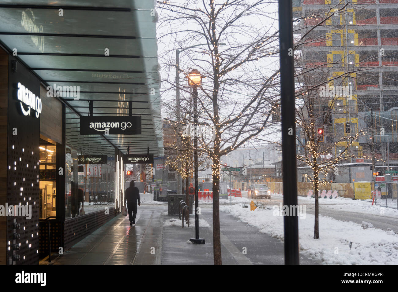 Amazon gehen Schaufensterwerbung in der Innenstadt von Seattle während einer Winter Schnee Sturm, Fußgänger auf dem Bürgersteig. Stockfoto