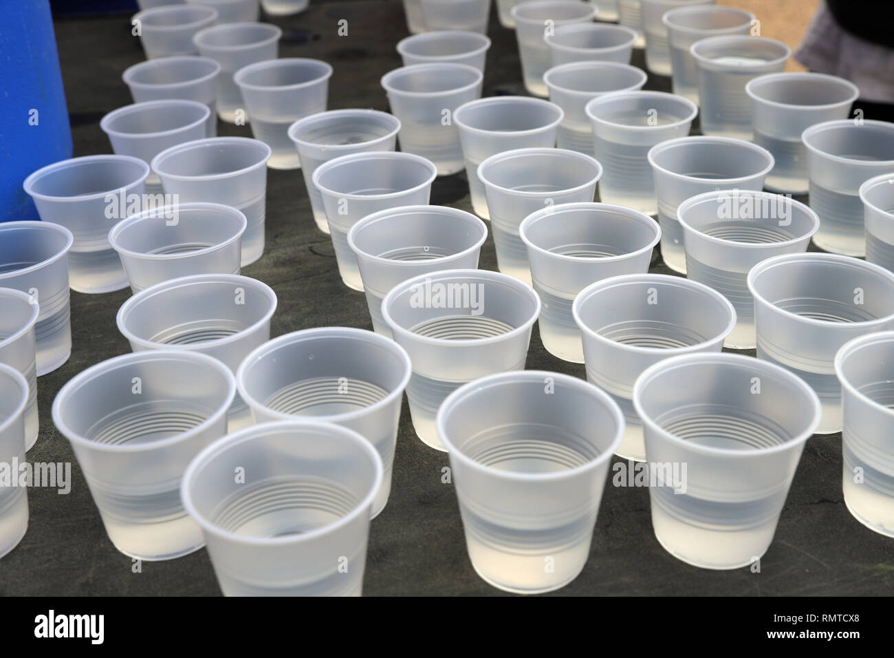 Disposeable aus Kunststoff Tassen auf dem Tisch für das Trinken an einer Straße Rennen. Kunststoff Recycling Stockfoto