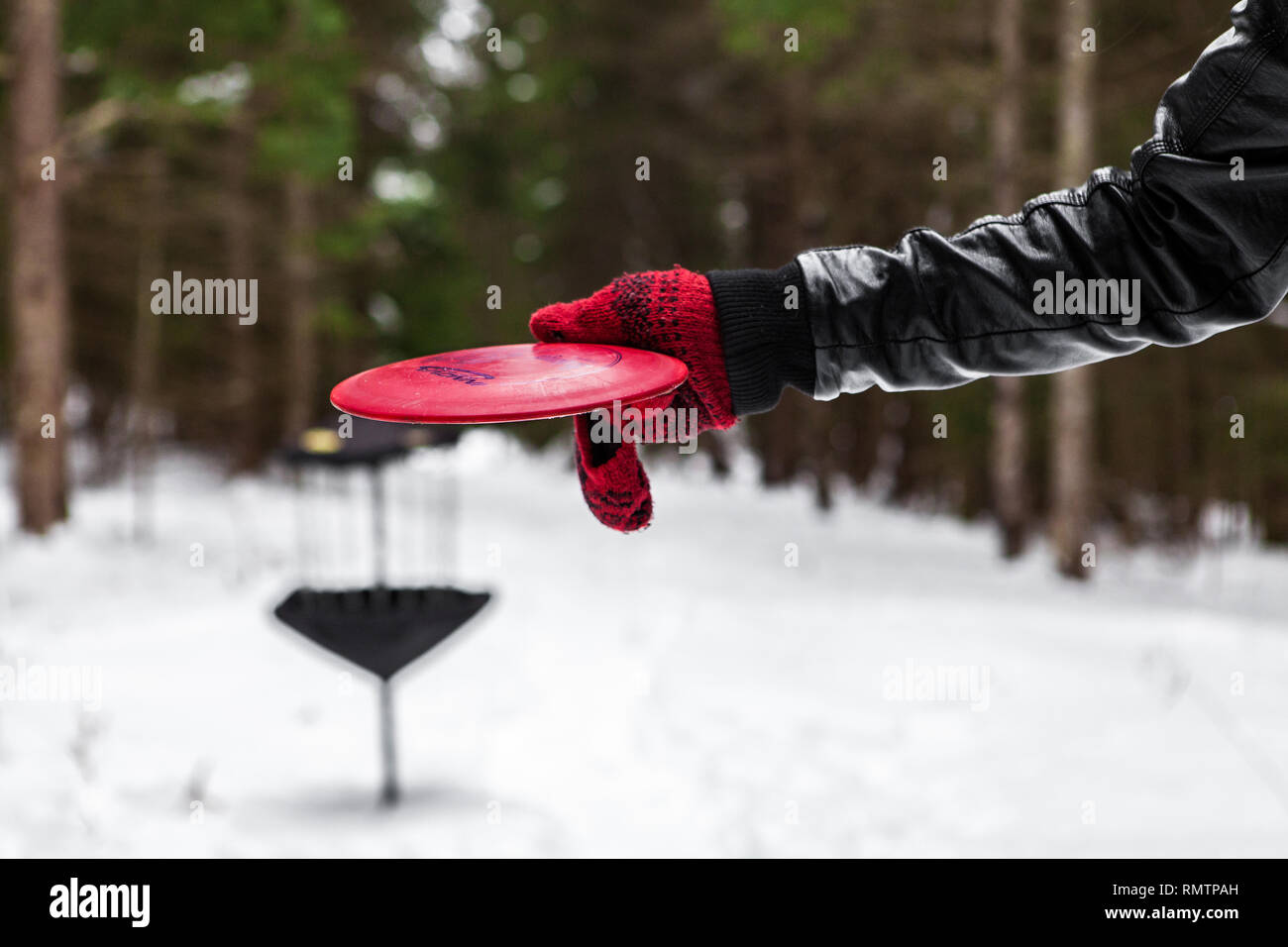 Mann spielt frizbee golf im Winter Stockfoto