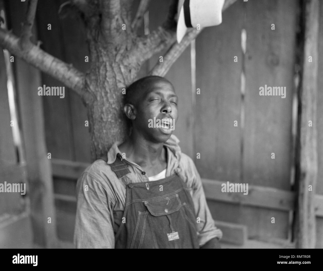 Mann gegen Baum, Florenz County, South Carolina, USA, Farm Security Administration, 1938 Schlafen Stockfoto