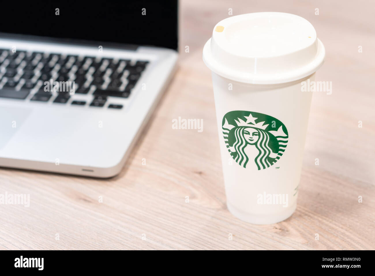 Starbucks Kaffeetasse auf dem Schreibtisch im Büro neben Computer Laptop. Slowenien 13.02.2019 Stockfoto