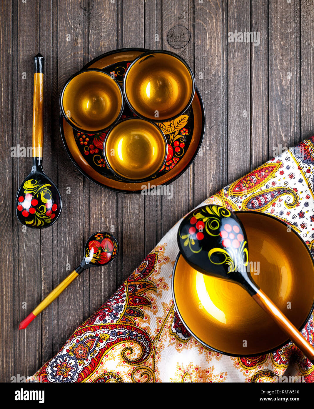 Holz- Gerichte, mit floralen Ornament im Stil von Khokhloma russischen Holz Kunst gemalt auf dem Tisch mit Schal. Stockfoto
