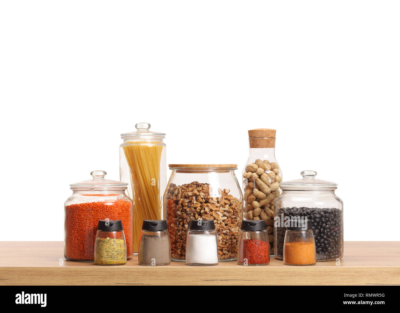 Sammlung von Gläsern mit unterschiedlichen Zutaten und Gewürzen auf einer Küchenarbeitsplatte auf weißem Hintergrund Stockfoto