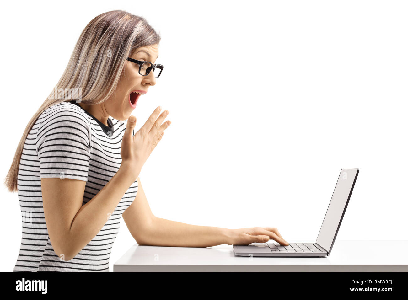 Überrascht junge Frau an einem Laptop auf weißem Hintergrund suchen Stockfoto