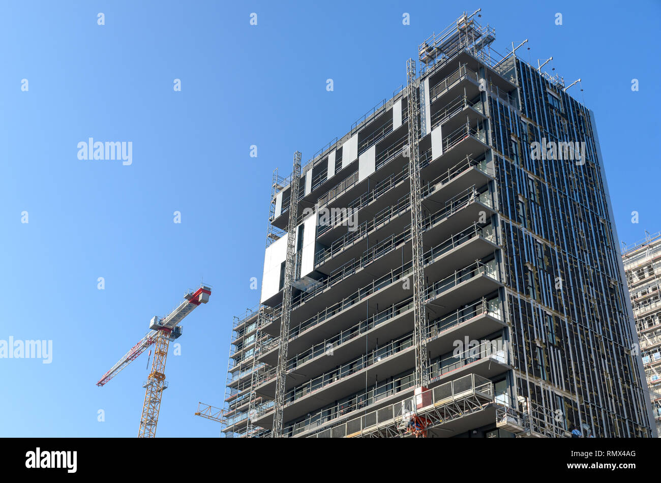 Kran und Gebäude im Bau gegen blauen Himmel Stockfoto