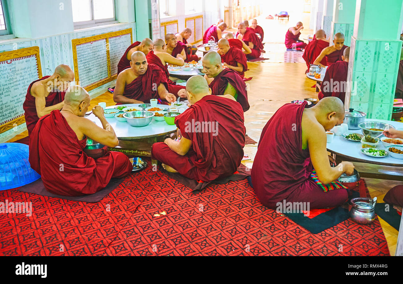 BAGO, MYANMAR - Februar 15, 2018: Der bhikkhu Mönche haben ein Mittagessen im großen Speisesaal des Kha Khat Waing Kyaung Kloster, am 15. Februar in Bago. Stockfoto