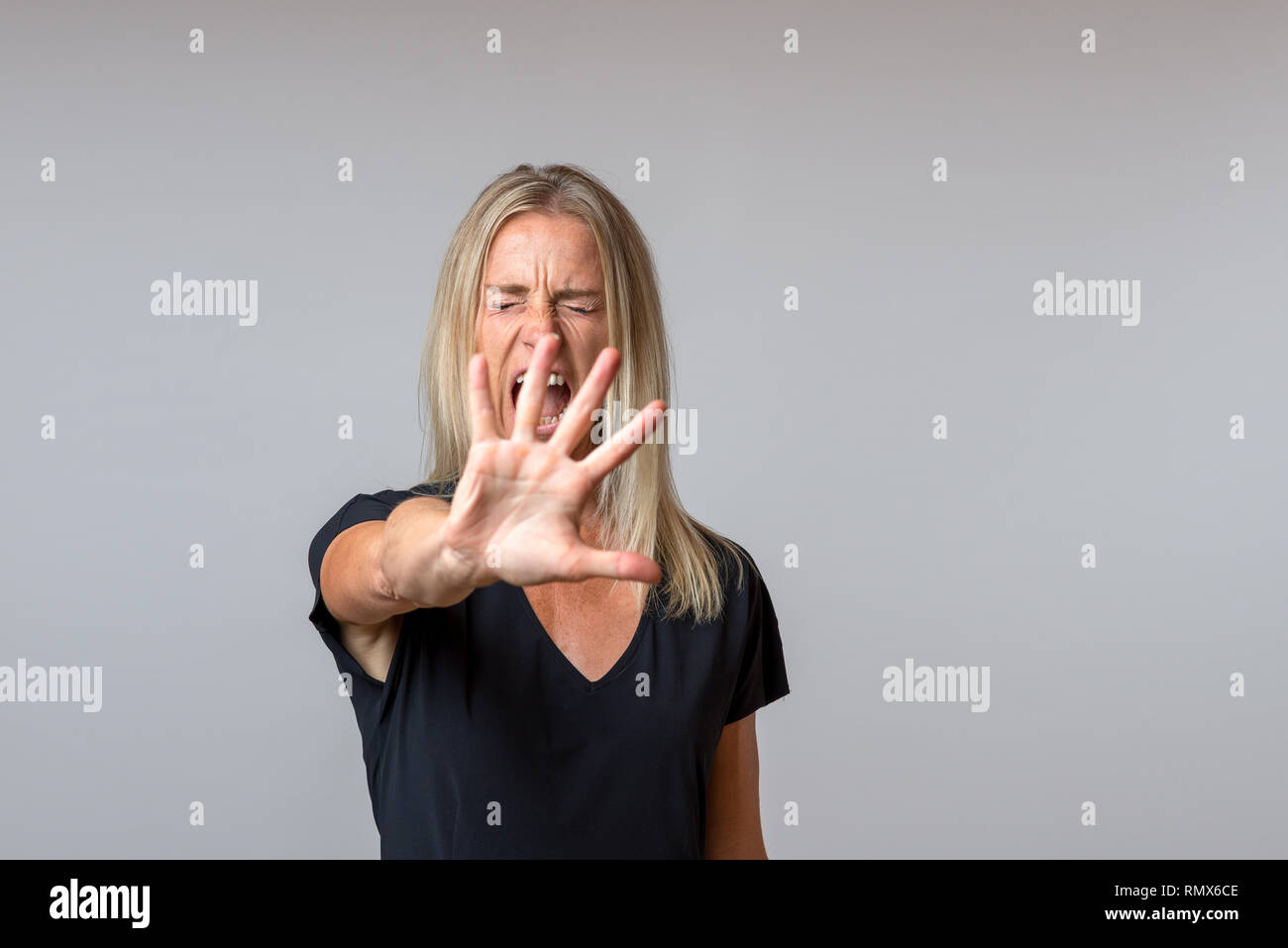 Gebieterisch arrogante Frau und deutete mit der Hand in einer abweisenden Geste während Schreien Stockfoto