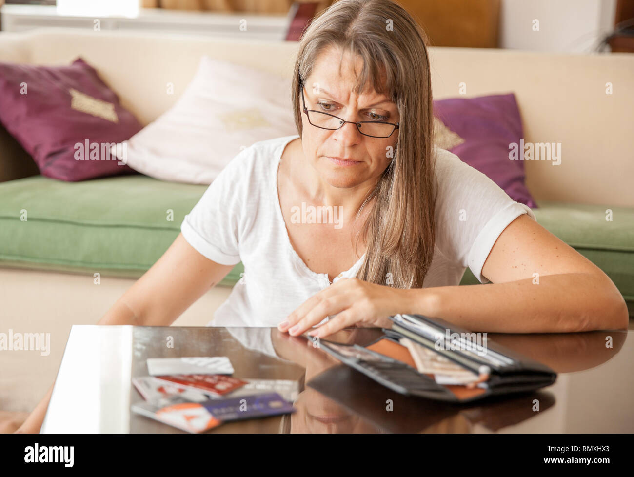 Reife Frau ist aufgebracht, an die Kreditkarten aus der Brieftasche zu suchen Stockfoto