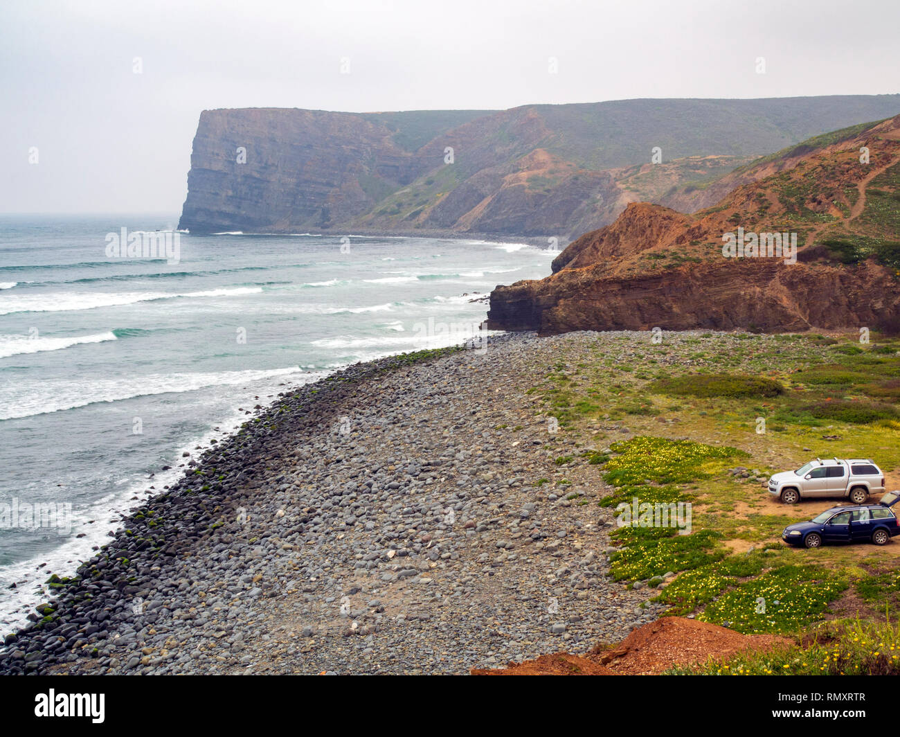 Autos an einem Surf Spot am Strand von Arrifana, einem kleinen Dorf beliebt bei Surfern im Süden von Portugal westliche Küste. Stockfoto