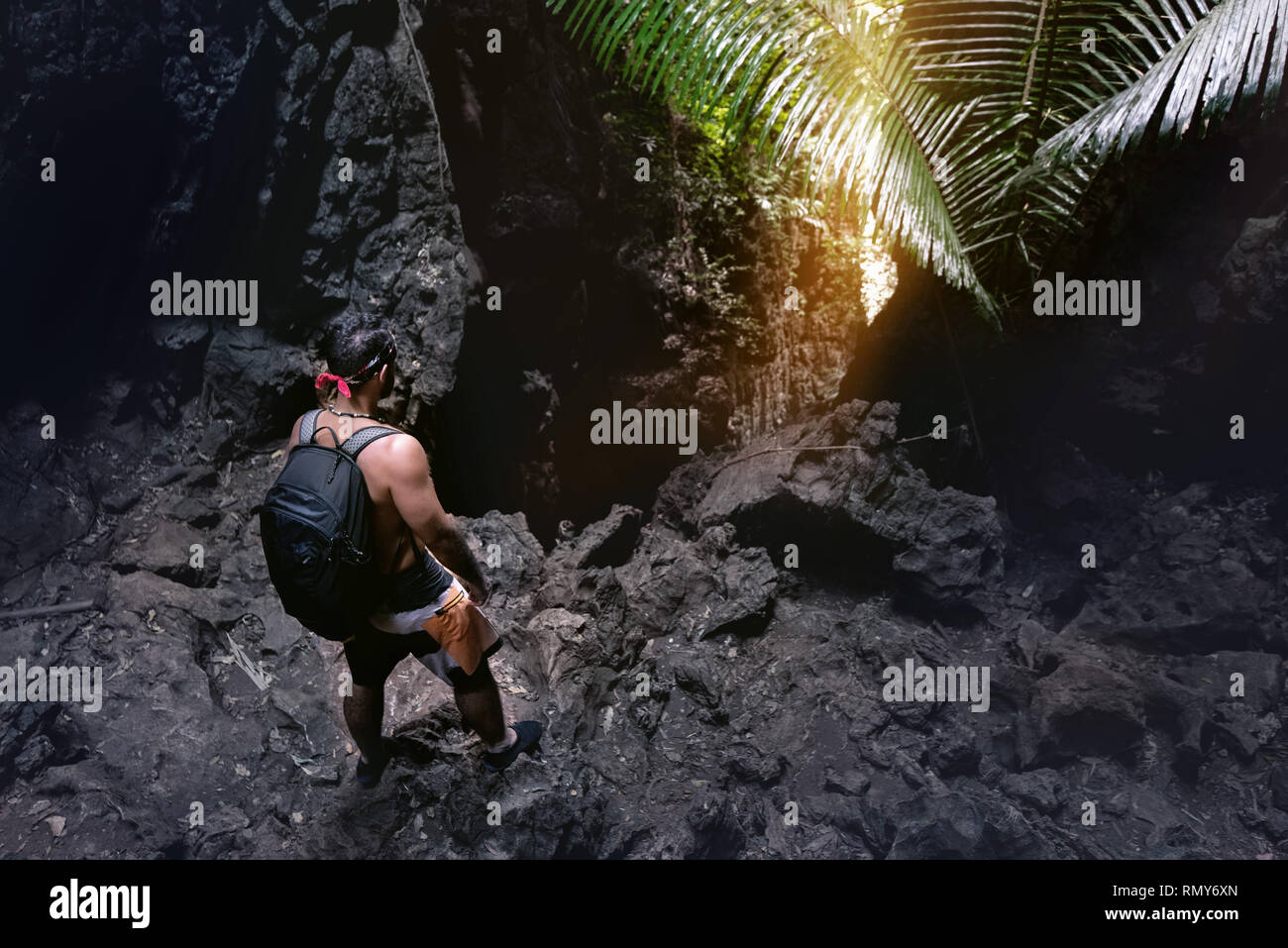 Mann Kletterer steht in der Nähe der Höhle verlassen oder Big Rock in der Dunkelheit Stockfoto