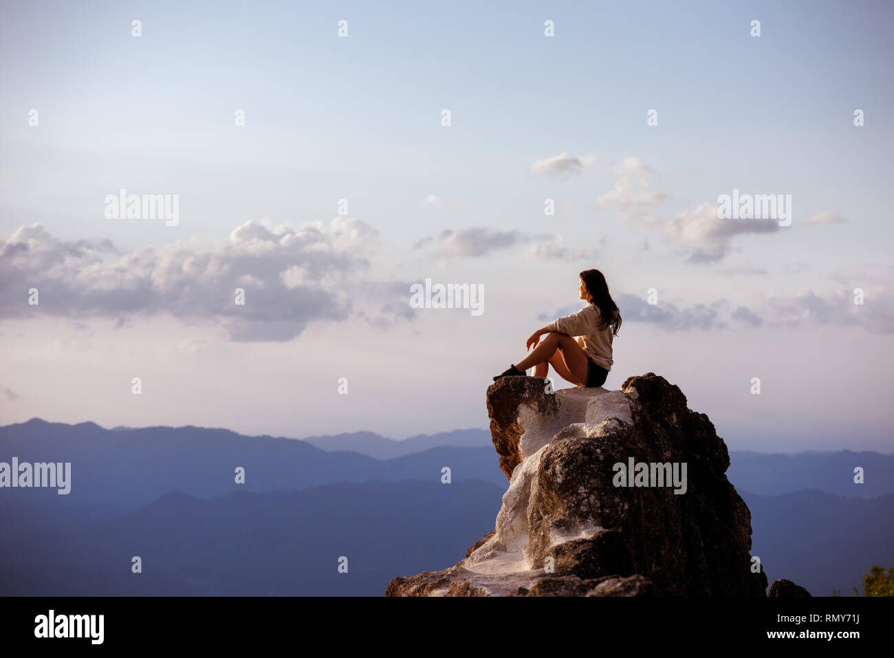 Schöne Mädchen sitzt auf Big Rock bei Sonnenuntergang Zeit und entspannen. Platz für Text Stockfoto