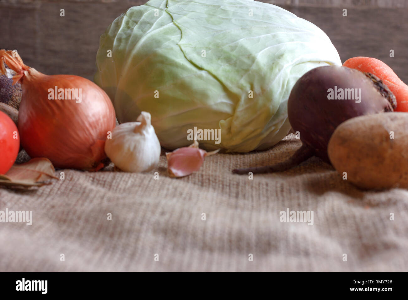 Rohes Gemüse für Zuckerrüben Suppe Borschtsch. Weisskohl, Rüben, Karotten, Kartoffel, Tomate, auf Holzbrett Knoblauch Stockfoto