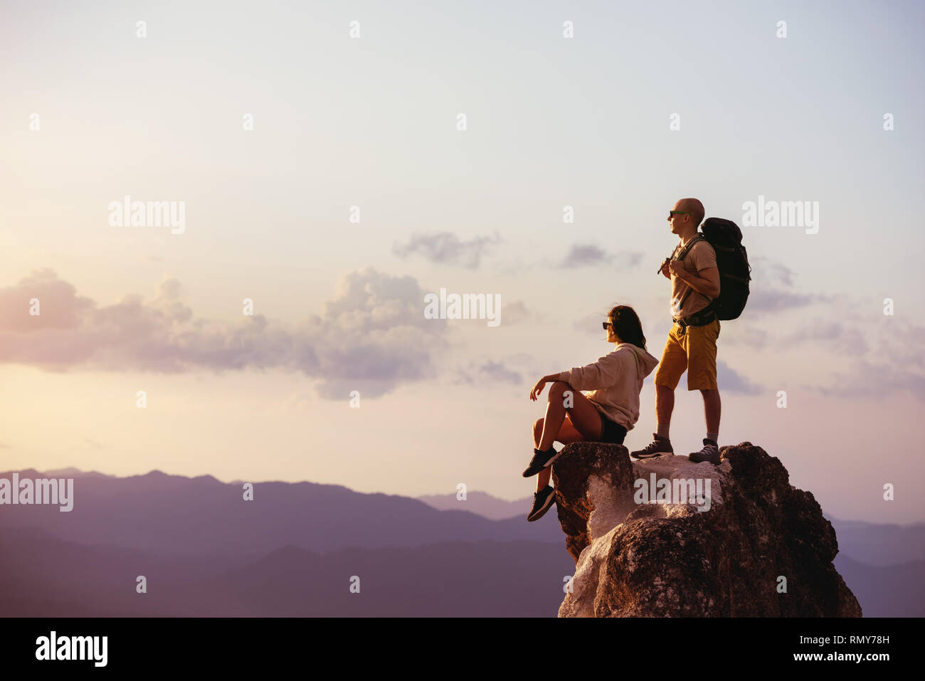 Paar backpackers Entspannen auf Big Rock bei Sonnenuntergang. Platz für Text Stockfoto