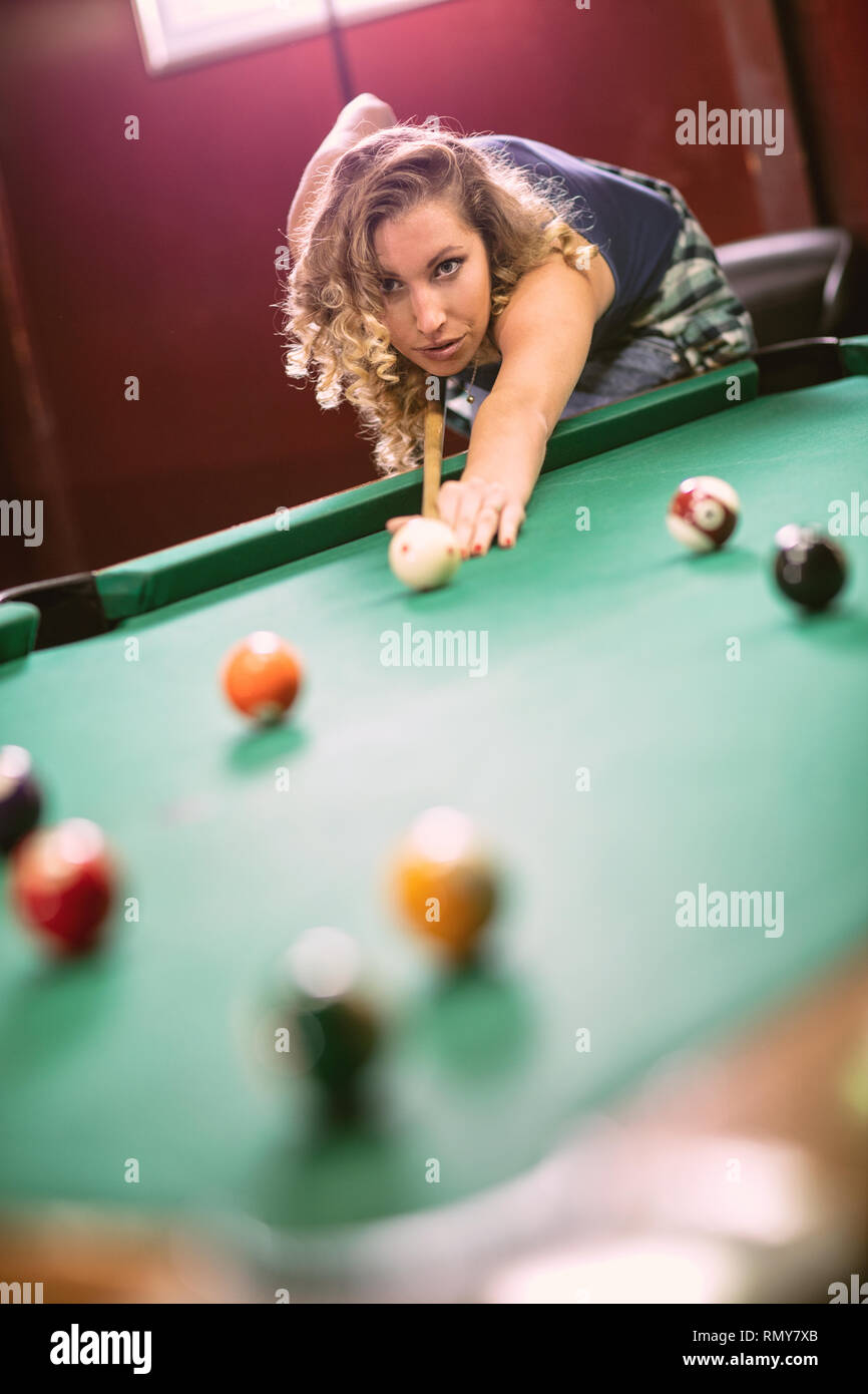 Schöne junge Frau, die darauf abzielt, die snooker Schoß zu nehmen Stockfoto