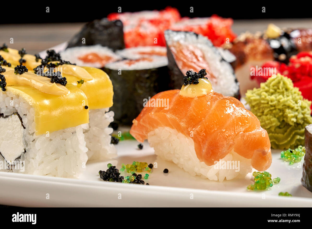 Willen Nigiri und Käse Brötchen hautnah. Lecker japanisch Essen. Eingestellt von Sushi und Maki uramaki mit Mayo eingerichtet, schwarzen Kaviar, serviert mit Wasabi auf weiße Platte. Stockfoto