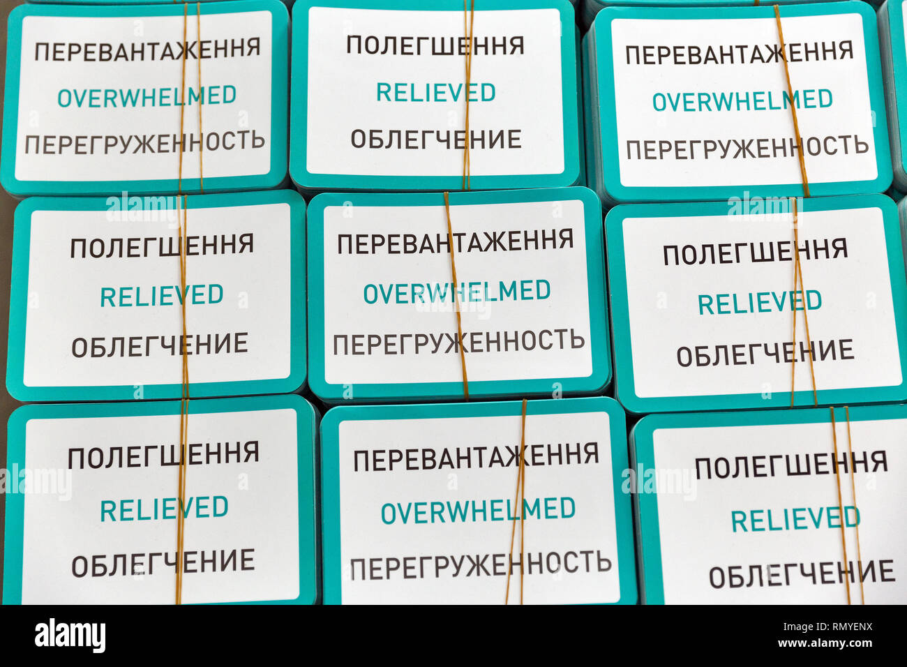 Stapel von Karten mit Inschriften: überwältigt und in Ukrainisch, Englisch und Russisch sprachen erleichtert, Nahaufnahme Stockfoto