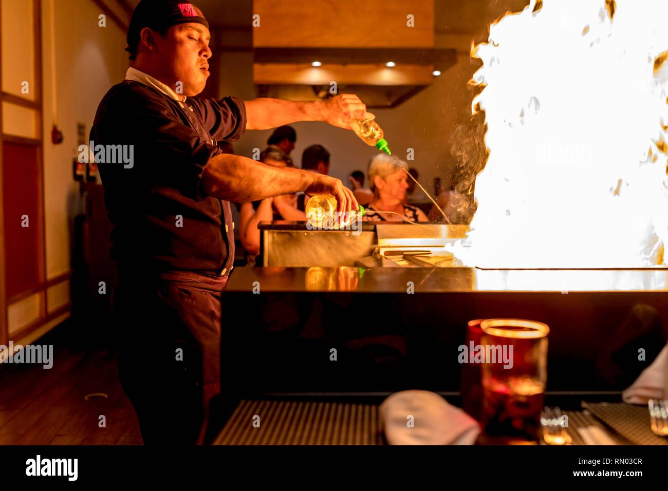 Riviera Maya, Mexiko - 28. Juli 2018. Japaneses Tepanyaki Koch unterhält die Gäste in einer luxuriösen Restaurant mit einer spannenden Show von Flammen auf ein heisses schieben Stockfoto