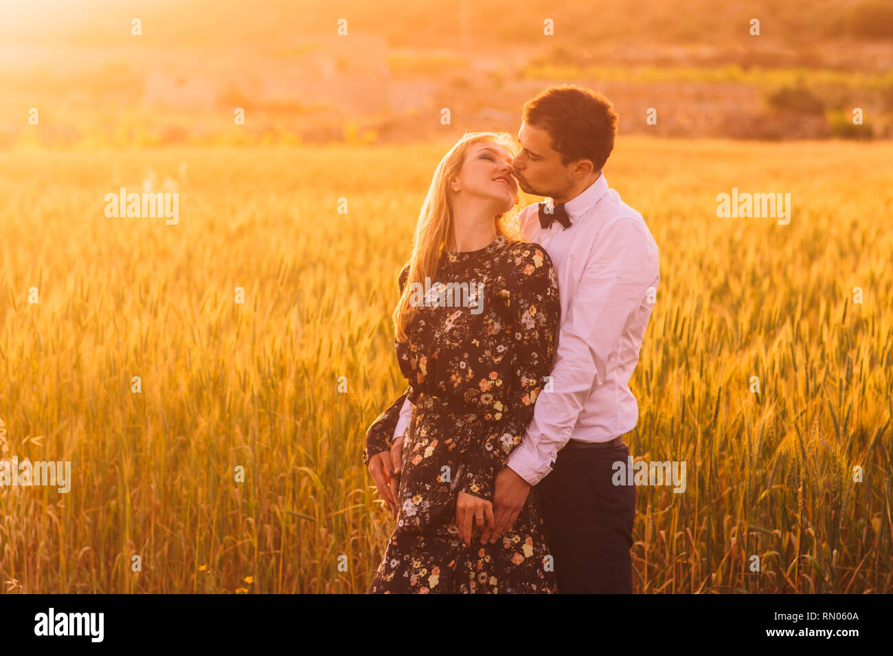 Der Mann und die Frau mit geschlossenen Augen Umarmen und Küssen in Weizen Feld in der Dämmerung, Landschaft Malta Stockfoto