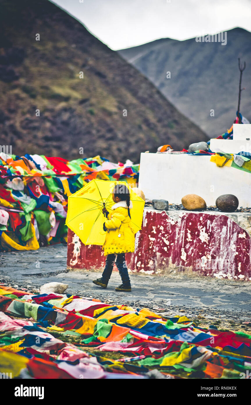 Tagong, China am 12. Mai 2015 - Blick auf Mädchen mit yellow umbrella gehen rund um tibetische Stupa Stockfoto