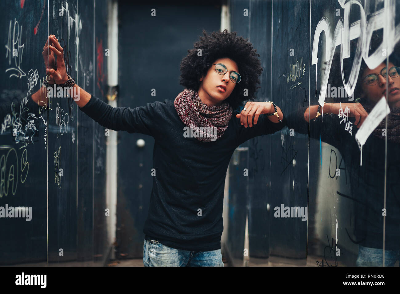 Junge Afro-amerikanische junge Unternehmer oder Student trägt schwarzen Rollkragenpullover Pullover und Schal und Lockige dunkle Haare. Konzept der stilvolle und Mode Stockfoto