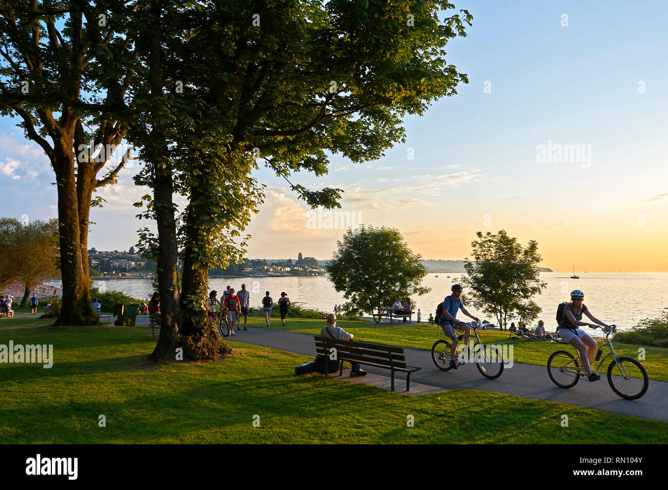 Junges Paar Radfahren, Wandern oder Joggen am späten Nachmittag und genießen den Sonnenuntergang am Staneleys Park in British Columbia, Vancouver, Kanada Stockfoto