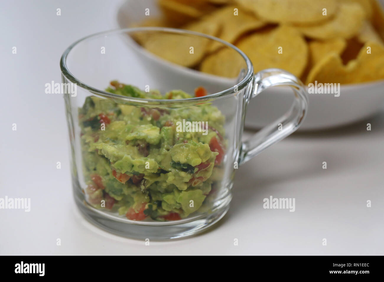 Mexikanische guacamole mit Mais Nachos. Die Guacamole ist hausgemacht, frisch und köstlich und es ist im Vordergrund dieses Foto. Closeup Foto. Stockfoto