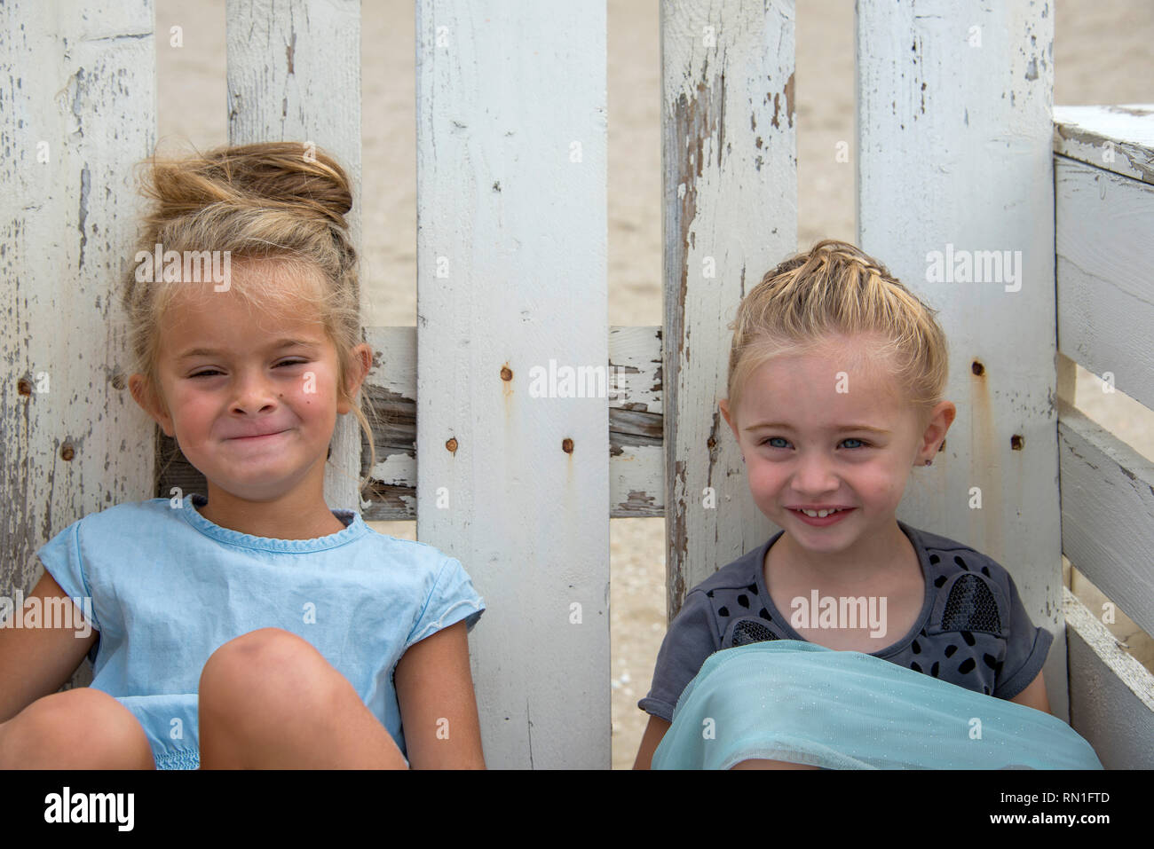 Rockanje, Niederlande, 29-Aug-2015: twol bisschen Mädchen sitzt auf einem Stuhl Maid von Paletten und schauen und lächeln in die Kamera Stockfoto