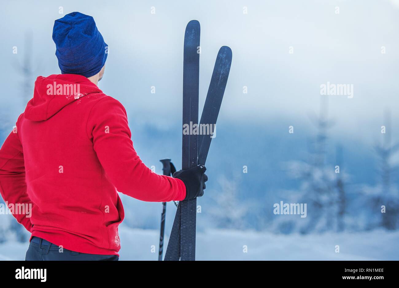 Winter Sport Thema. Kaukasische Skifahrer mit Ski in der Hand Nahaufnahme. Stockfoto