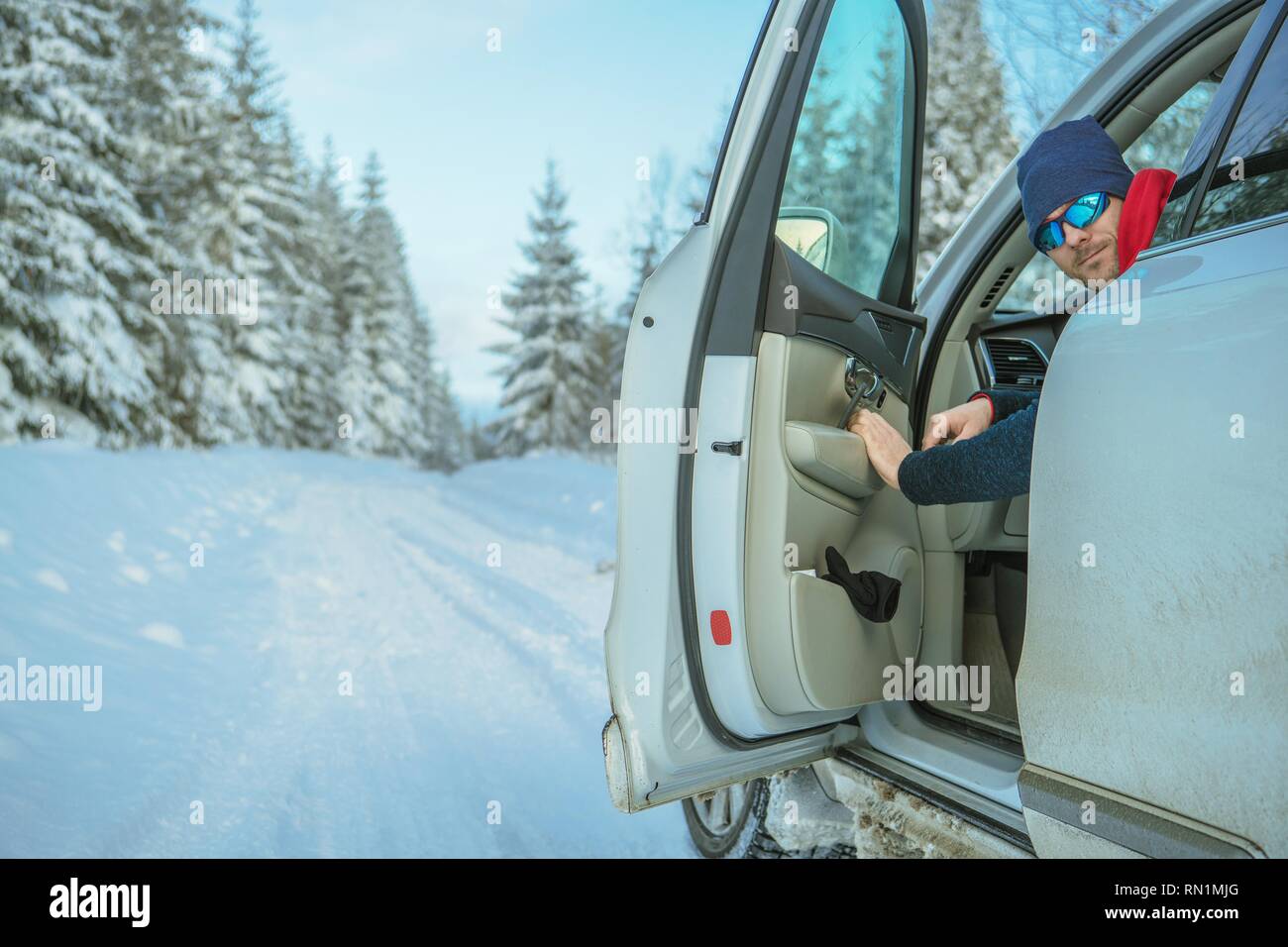 Winter Road Trip. Lächelnd kaukasischen Treiber Nehmen ein Blick zurück in das Auto. Stockfoto