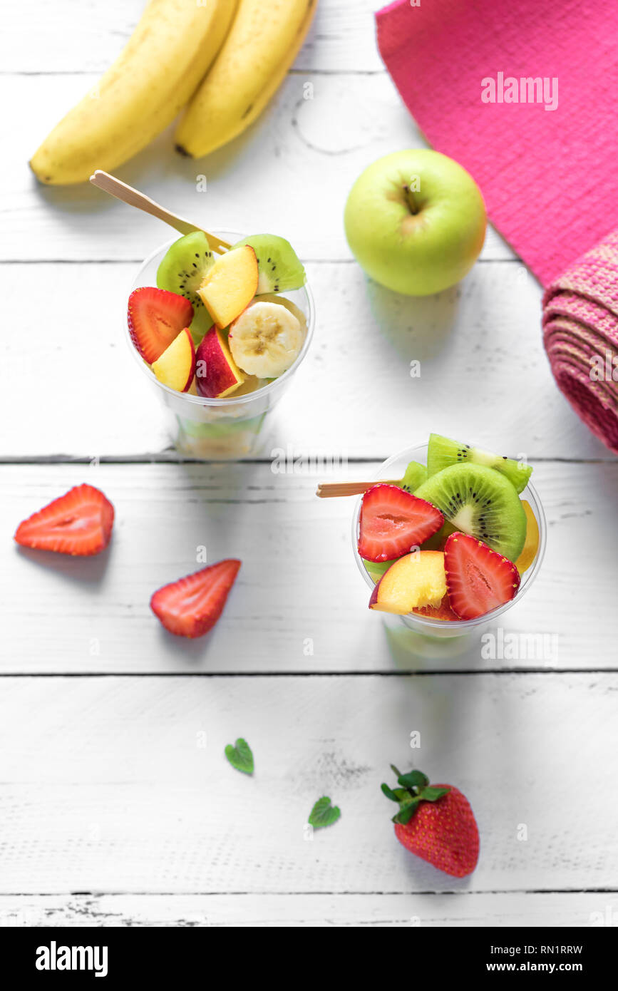 Feminine Sport und gesunder Lebensstil Konzept. Rosa Yoga Matte und Obst und Beeren Salat in Schale aus Kunststoff zu gehen, Platz kopieren, Ansicht von oben. Stockfoto