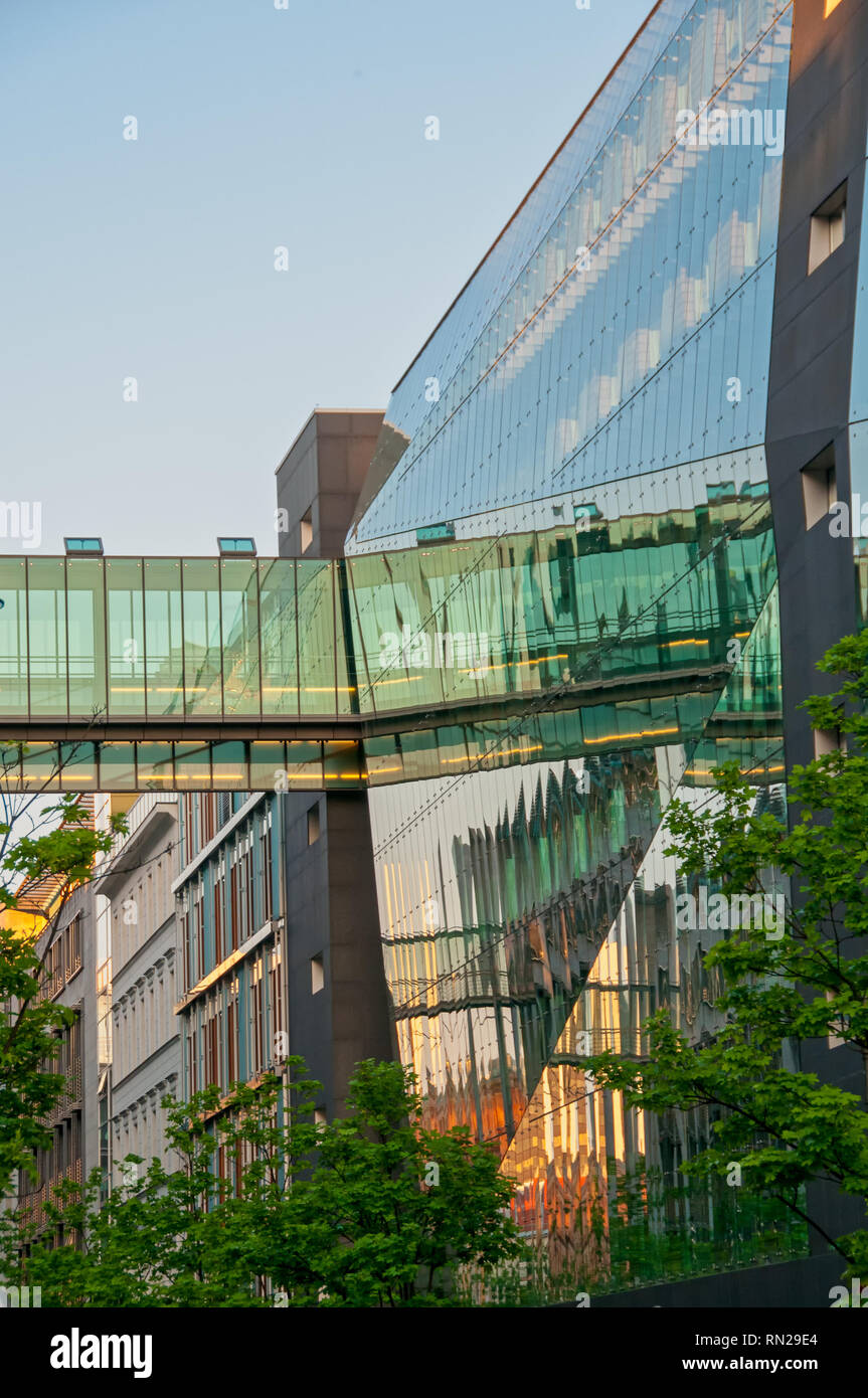 Moderner urbaner Architektur, Glas- und Stahlkonstruktion, den Sonnenuntergang und die Fußgängerbrücke in Windows widerspiegelt, historischen Häusern im Hintergrund, Berlin Stockfoto