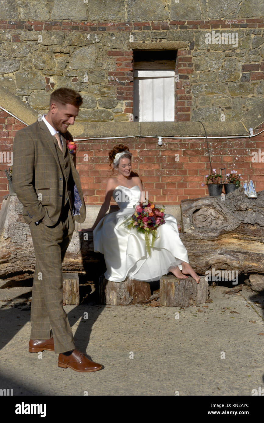 Ein schönes Paar erhalten, in einem romantischen Bauernhof Lage verheiratet - Sie ist eine Rothaarige und wers eine kurze vintage Wedding Dress. Er ist gross und hat Tatoos Stockfoto