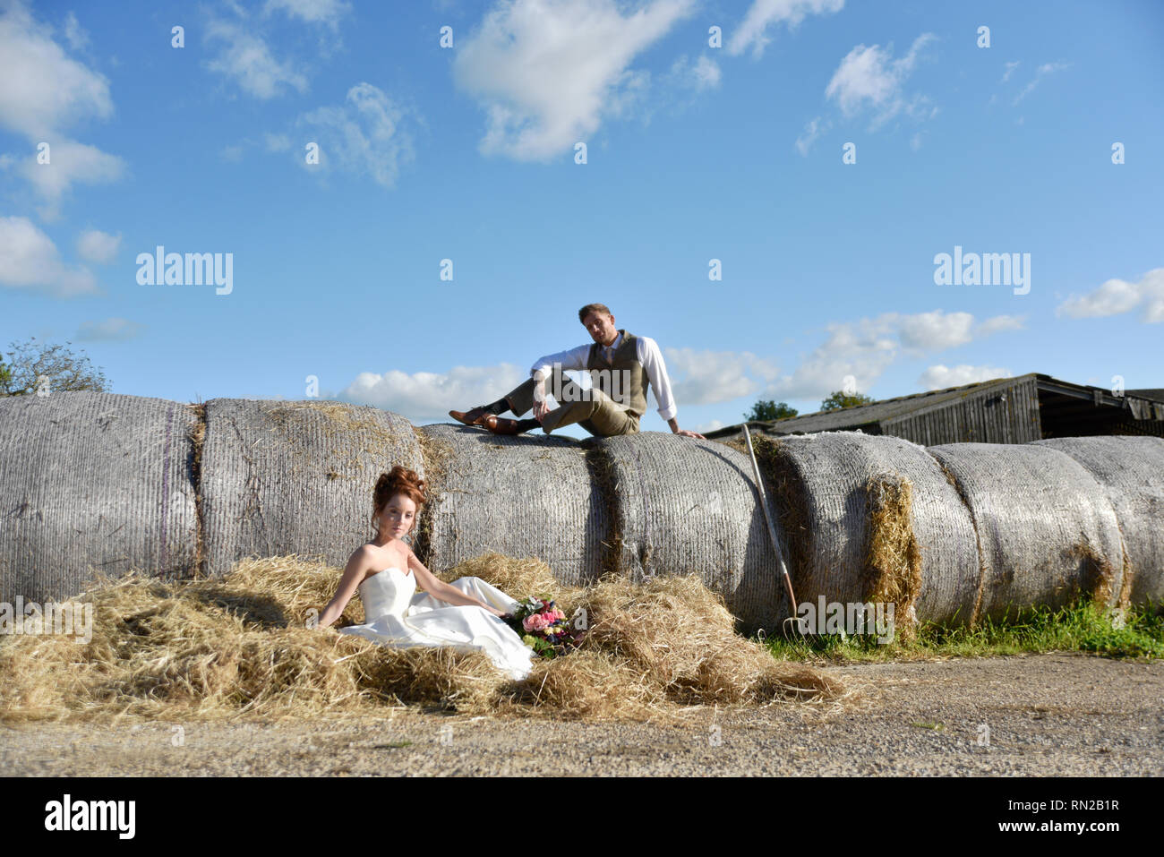 Ein schönes Paar erhalten, in einem romantischen Bauernhof Lage verheiratet - Sie ist eine Rothaarige und wers eine kurze vintage Wedding Dress. Er ist gross und hat Tatoos Stockfoto