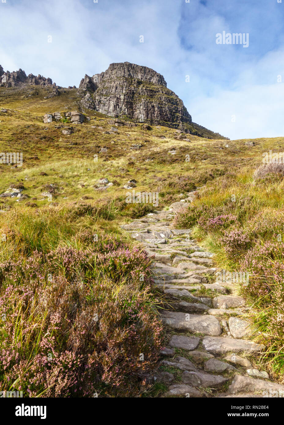 Ein wandern Wanderweg steigt durch Heather und Felsen auf dem Gipfel des Stac Pollaidh Berg in Assynt in den Highlands von Schottland. Stockfoto