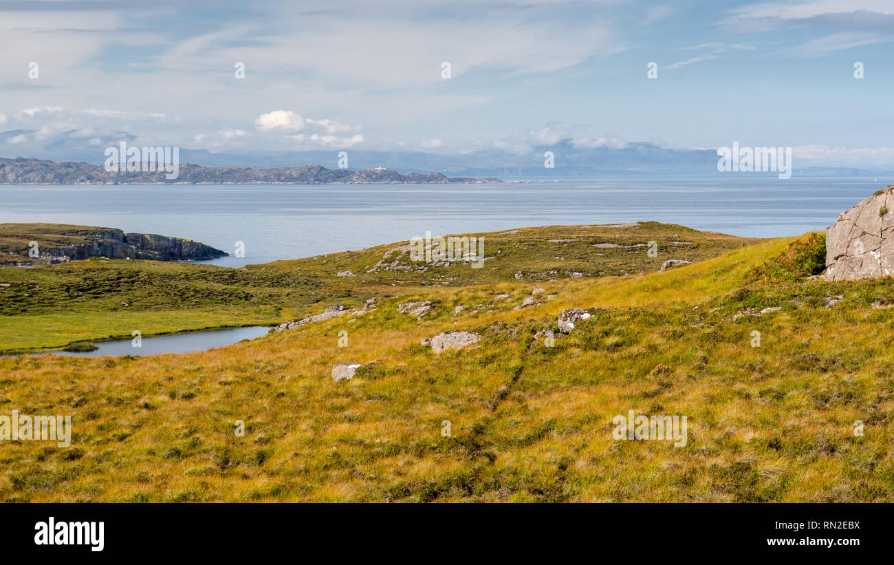 Die Sonne scheint auf das Moor auf den Applecross Halbinsel mit den Hebriden Inseln von Rona und Skye hinter, einschließlich Rona Leuchtturm und Berg Quiraing Stockfoto