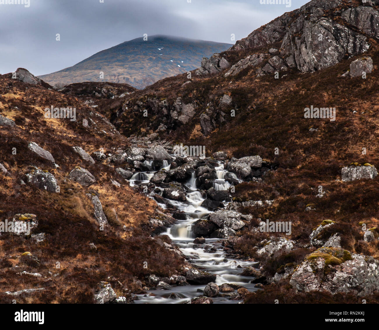 Ein kleiner Bergbach stolpert über Wasserfälle bei Easan Garbh in den Bergen des nördlichen Highlands von Schottland. Stockfoto