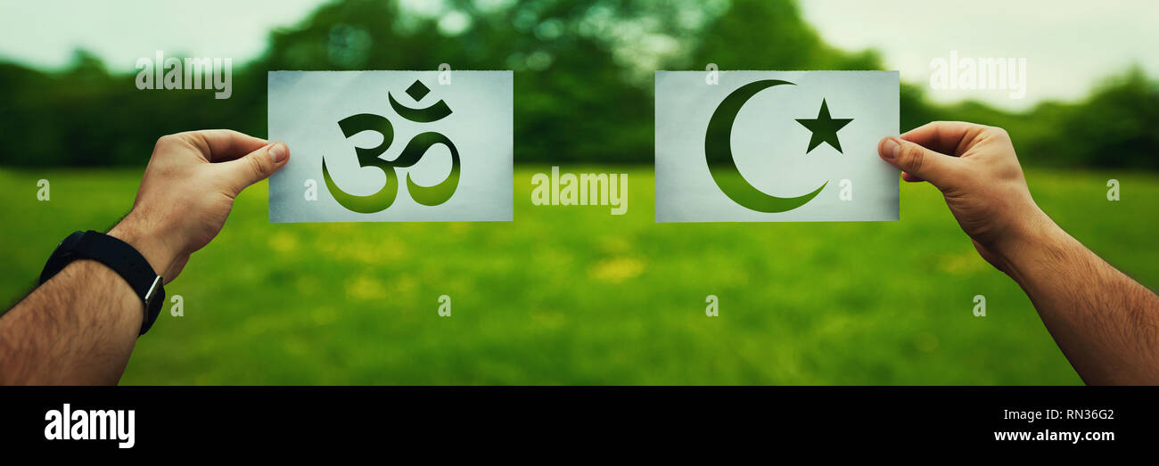 Religion Konflikte als globales Thema Konzept. Zwei Hände, die anderen glauben, den Islam, Hinduismus Symbole glauben über grüne Feld Natur vs. Beziehung Stockfoto