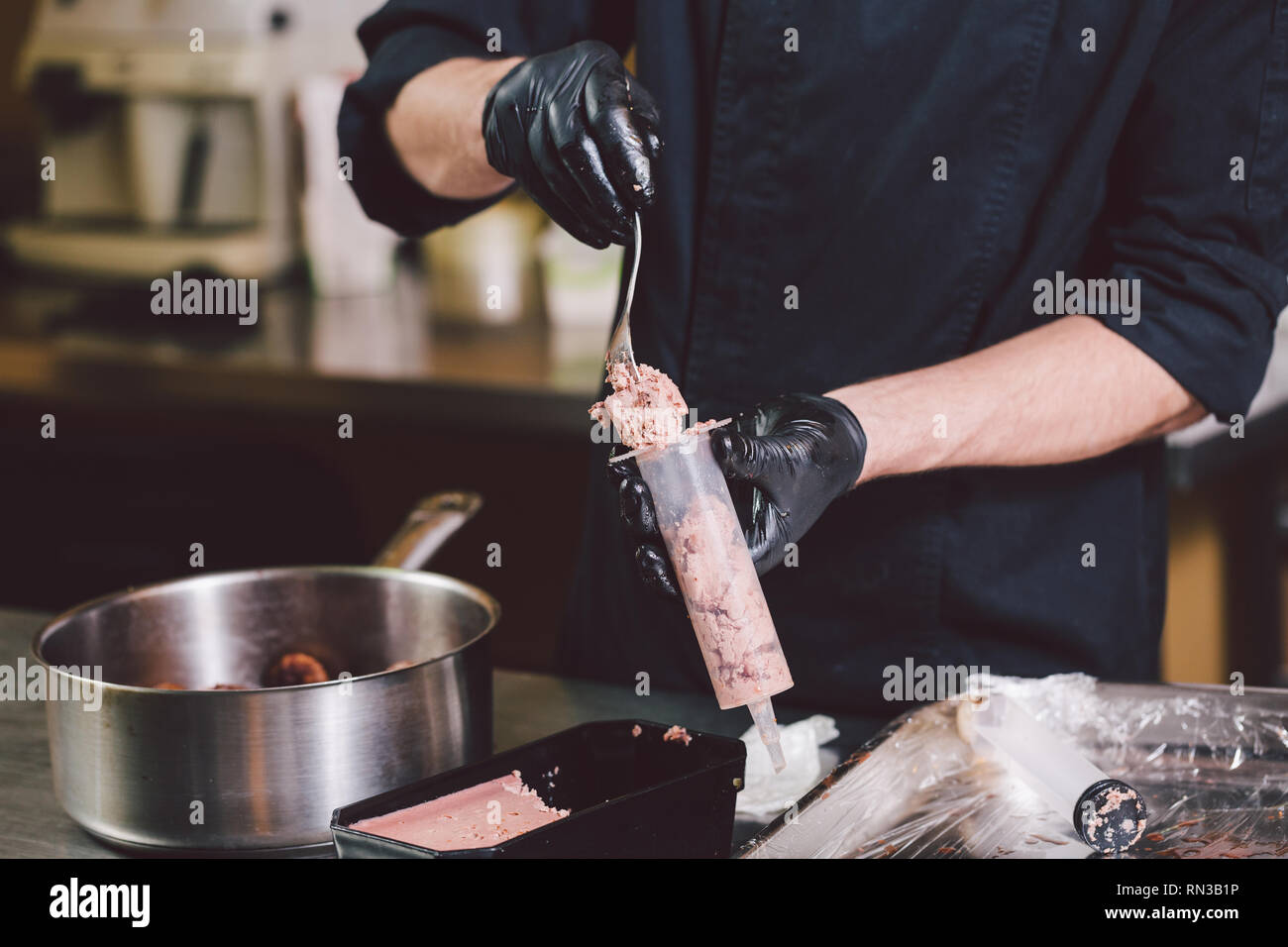 Thema kochen. Die Hände schließen oben. jungen kaukasischen Mann in  schwarzer Uniform und Latex Handschuhe in Küche. Restaurant bereitet  Rinderhackfleisch und führt in Berry Stockfotografie - Alamy