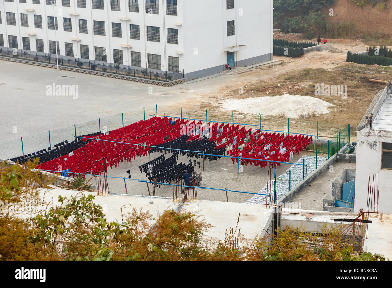 Dengfeng, China - 17. Oktober 2018: Die einheitliche Ausbildung der Schüler der Kampfkünste Schule ist auf einem Seil in der Straße nach der Wäsche getrocknet. Shaolin Tempel. Stockfoto
