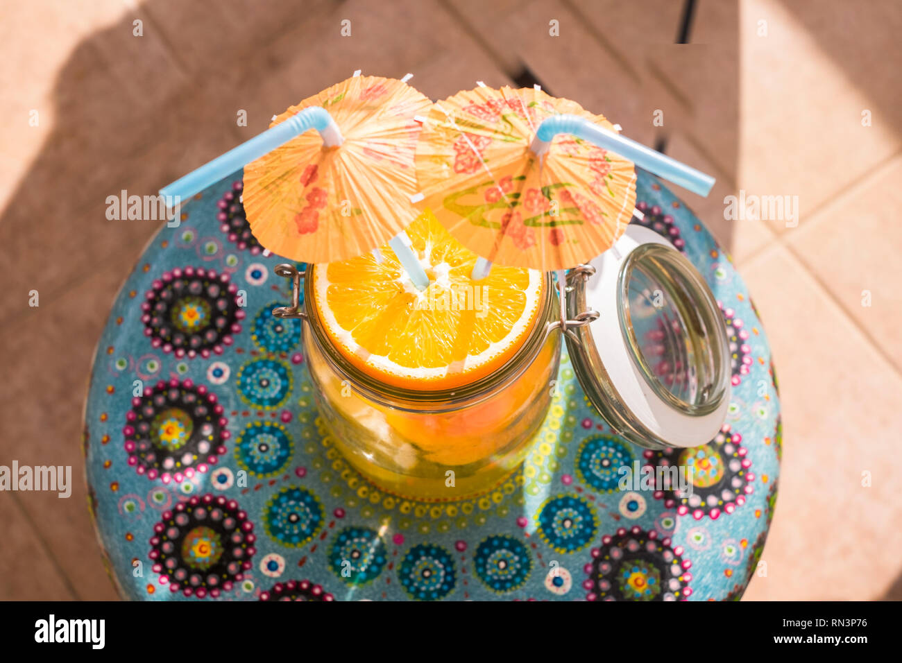 Fruchtcocktail Retro-Look mit Sonnenschirmen Aufenthalt auf einer Dachterrasse mit herrlichem Blick über die Dächer und auf das Meer. Blue Sky cloudly. Natürliches Getränk Sommer. Stockfoto