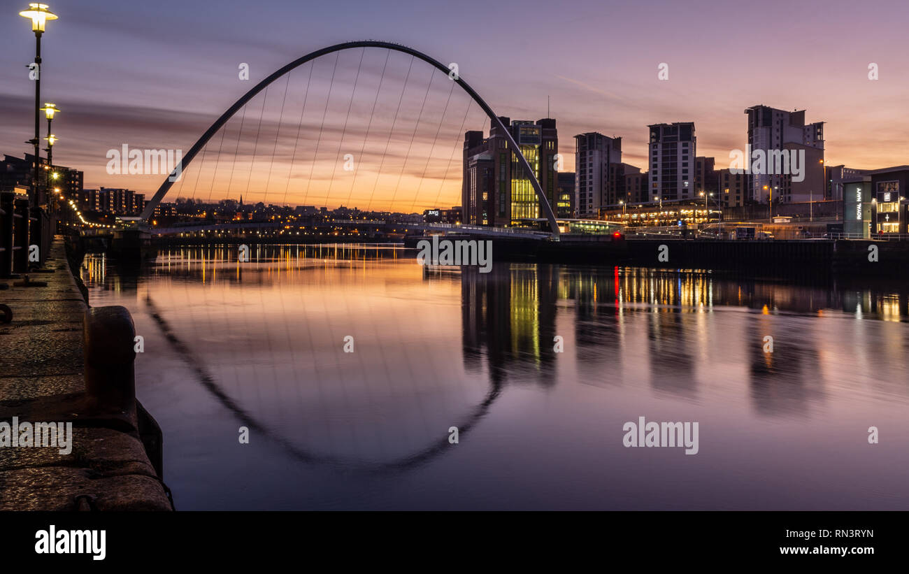 Gateshead, England, Großbritannien - Februar 5, 2019: Sonne beyhind der ikonischen Gateshead Millennium Bridge und BALTIC Mühlen aufbauend auf den Kais Stockfoto