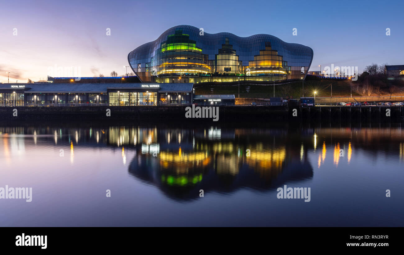 Gateshead, England, Großbritannien - Februar 5, 2019: Morgendämmerung erhebt sich über der Sage Gateshead Gebäude am Kai des Flusses Tyne. Stockfoto